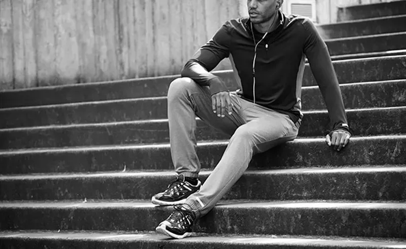 Hombre sentado en unas escaleras con ropa deportiva urbana
