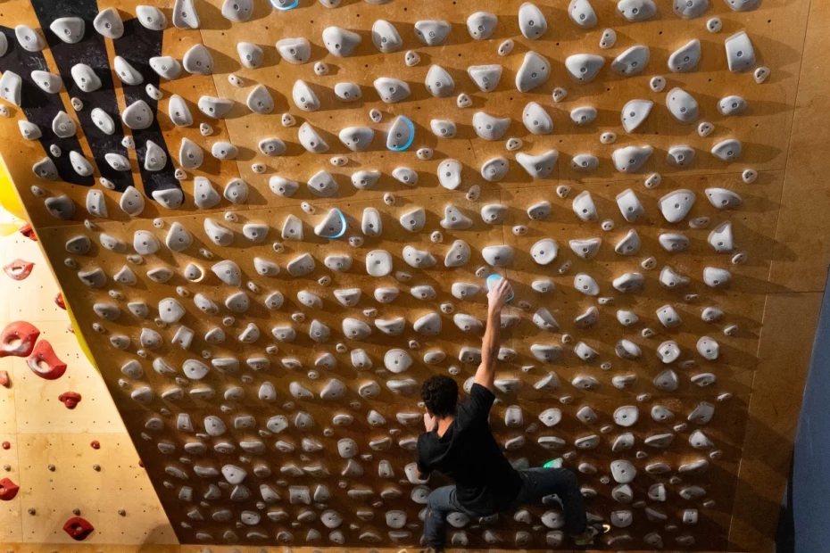 Escalador entrenando en un Kilter Board en el rocódromo Uadibloc, mejorando su fuerza y resistencia para la escalada deportiva.